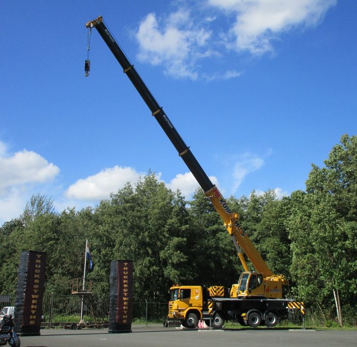 Crane lifting tree onto truck with protective rigging